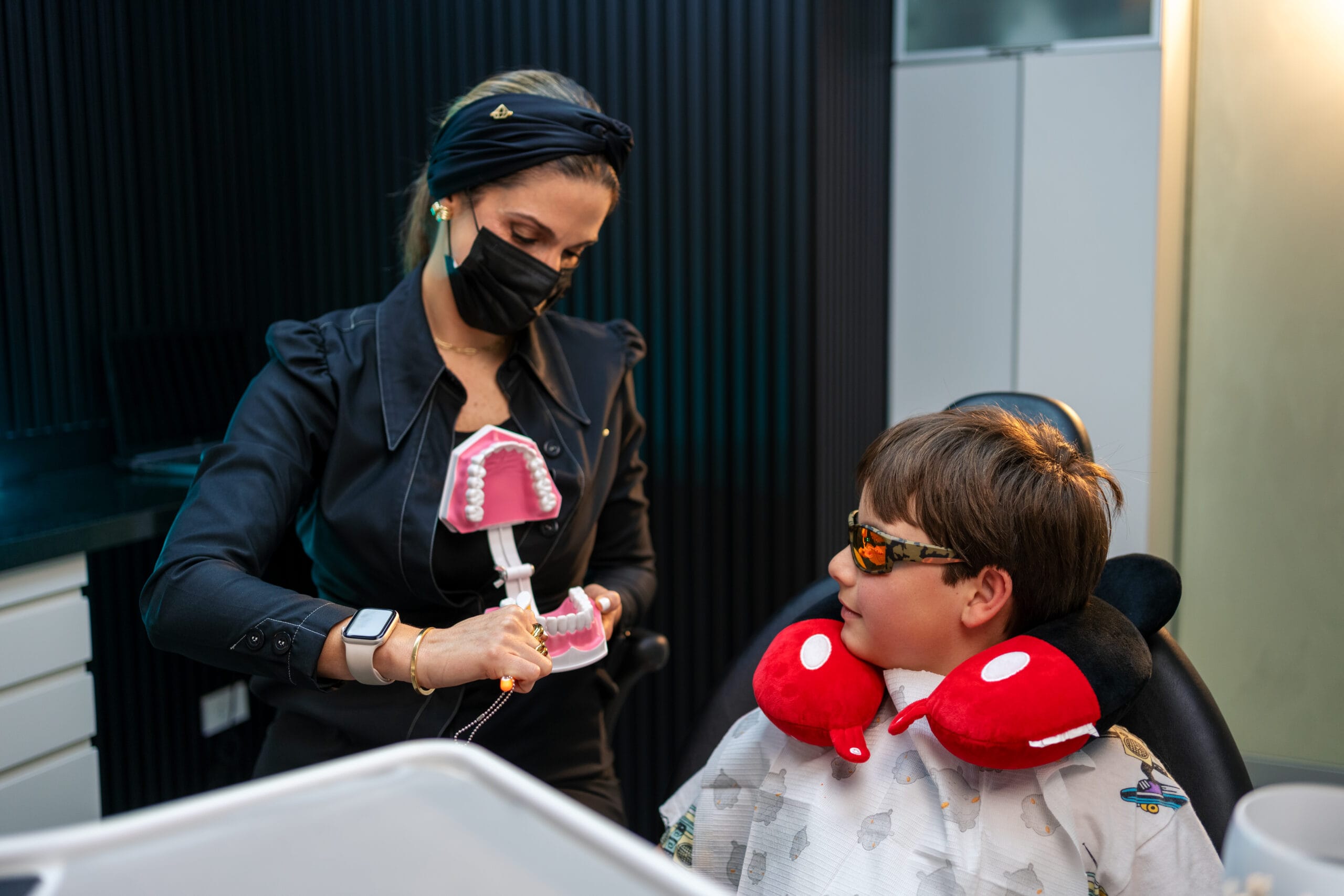 Profesional de AS Clínica Dental muestra un modelo dental a un niño durante una consulta odontopediátrica