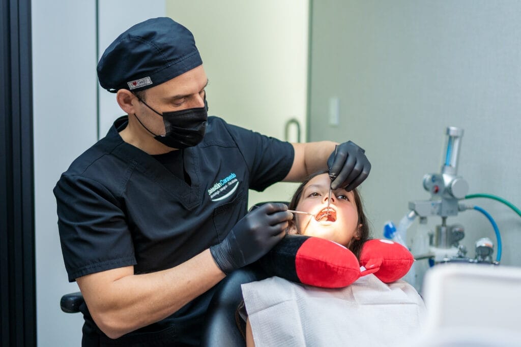 Odontólogo atendiendo a una paciente durante un tratamiento dental